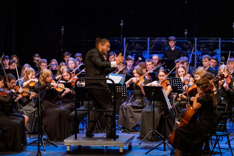 Maciej Cisowski dyryguje orkiestrą symfoniczną podczas koncertu "Na młodość chór i orkiestrę" w wykonaniu Młodej Filharmonii Międzyszkolnej w ramach IV Międzynarodowego Festiwalu im. Michała Spisaka. Fot. Marek Wesołowski